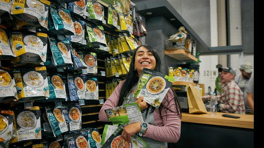Woman holding packaged freeze-dried meals at trade show booth display