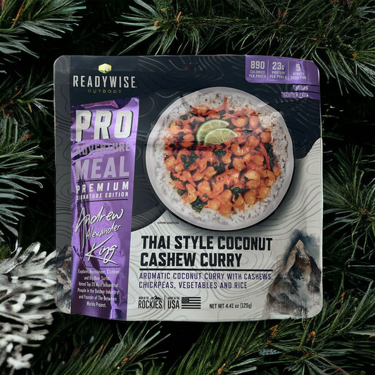 ReadyWise Thai style coconut cashew curry meal pouch on pine branches background